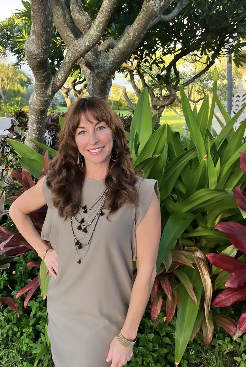 Jill standing among tropical foliage